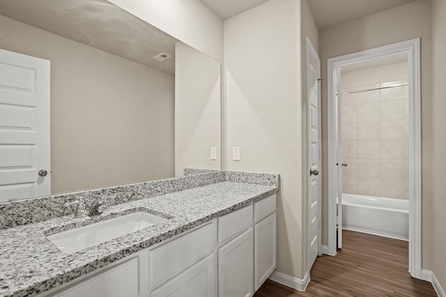 302 Elk Run Ln, Huntsville, TX 77320 - full bathroom with wood finished floors, vanity, baseboards, visible vents, and washtub / shower combination