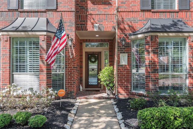 entrance to property featuring brick siding