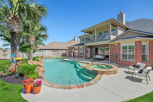 view of swimming pool featuring a patio area, a pool with connected hot tub, and a fenced backyard