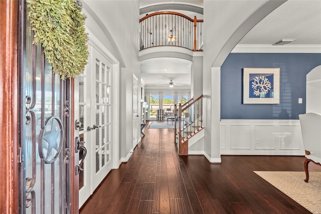 foyer with crown molding, french doors, wood finished floors, and visible vents