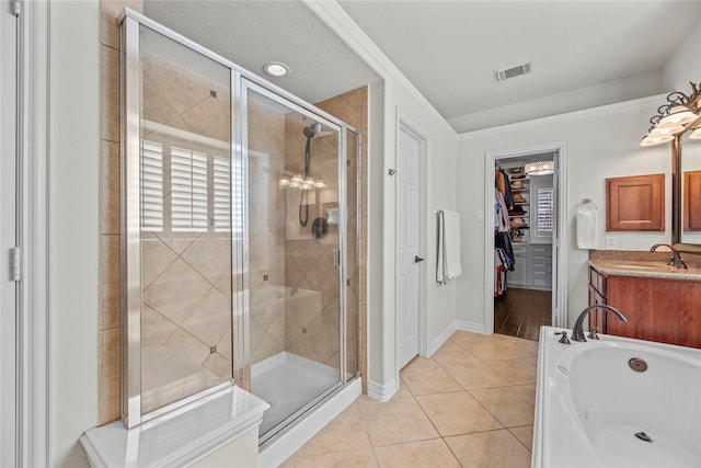 full bathroom featuring visible vents, a spacious closet, a shower stall, vanity, and tile patterned flooring
