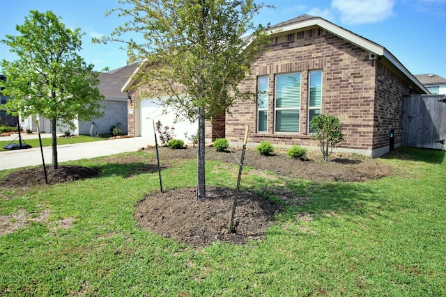 view of front facade featuring brick siding, a front yard, a garage, and driveway