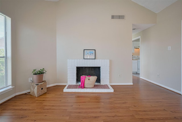 unfurnished living room featuring baseboards, visible vents, and wood finished floors