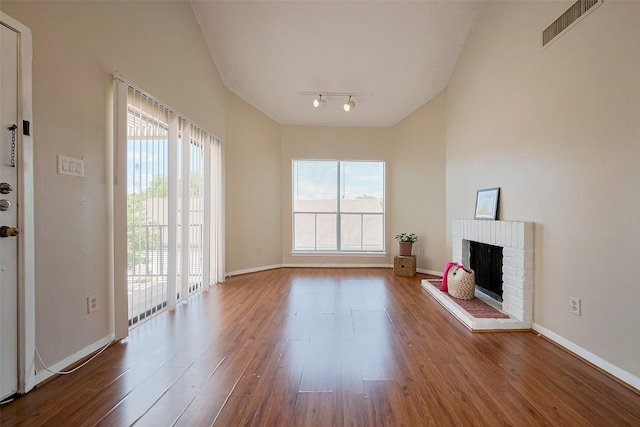 unfurnished living room with visible vents, wood finished floors, rail lighting, and plenty of natural light