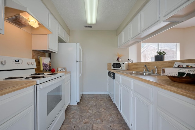 kitchen featuring white cabinetry, a sink, visible vents, white appliances, and range hood