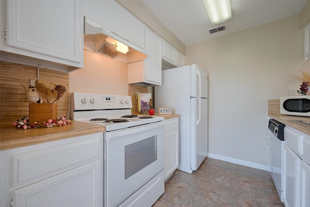 kitchen with white appliances, visible vents, baseboards, premium range hood, and white cabinets
