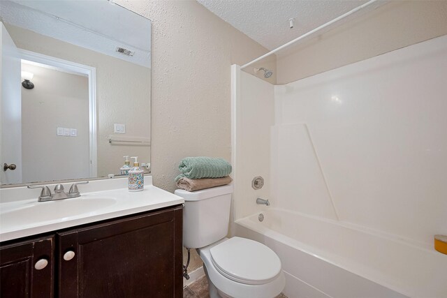 bathroom featuring toilet, vanity, visible vents, washtub / shower combination, and a textured ceiling