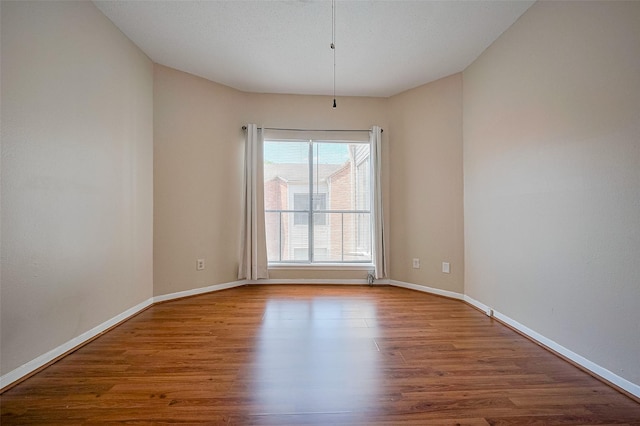 unfurnished room featuring wood finished floors and baseboards