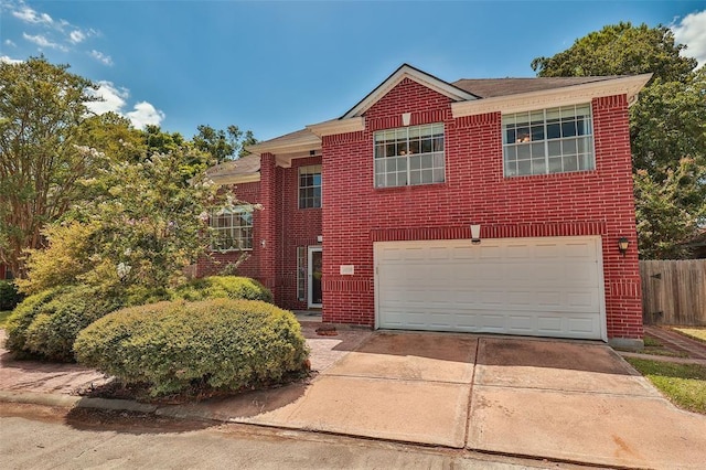 traditional-style house with brick siding, fence, a garage, and driveway