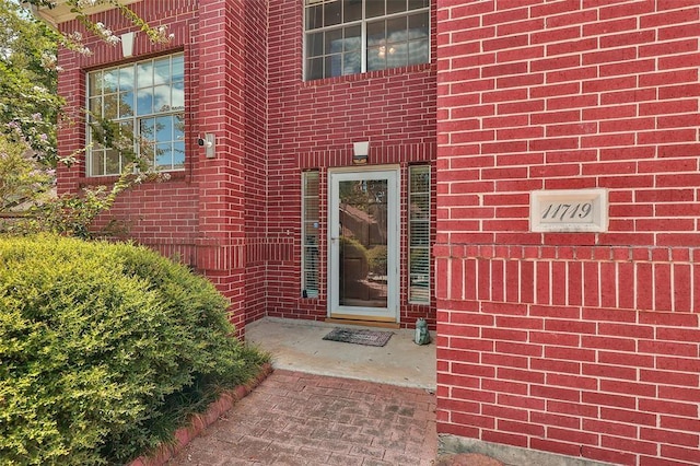 property entrance featuring brick siding