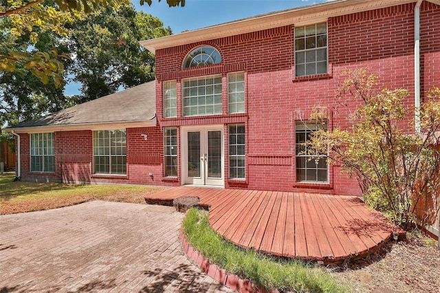 back of house with french doors, a deck, and brick siding