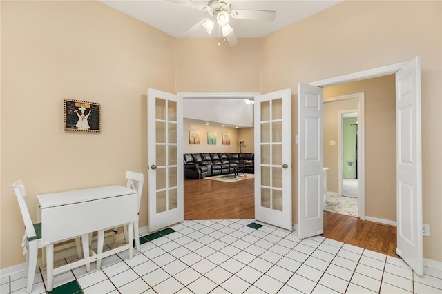 unfurnished dining area with light tile patterned floors, french doors, baseboards, and a ceiling fan