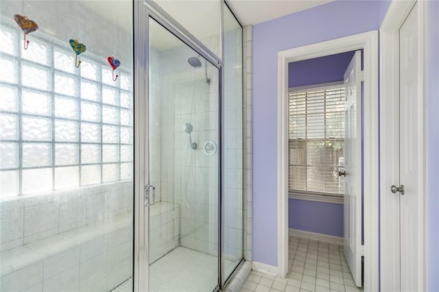 full bath with tile patterned floors, baseboards, and a stall shower