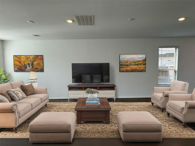 living area featuring wood finished floors, visible vents, and baseboards