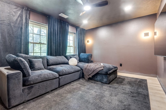 home theater with light wood finished floors, ceiling fan, visible vents, and recessed lighting