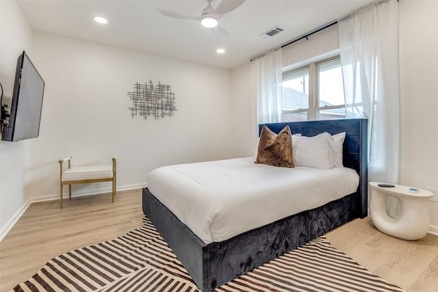 bedroom with light wood finished floors, visible vents, and baseboards