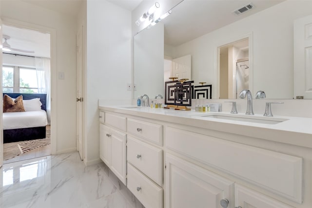 ensuite bathroom with a sink, visible vents, double vanity, and marble finish floor