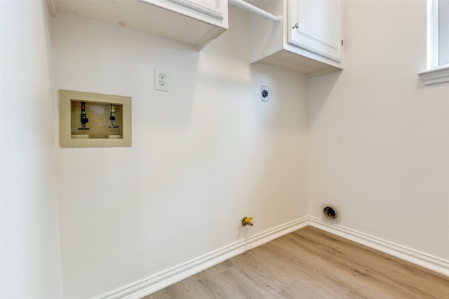 washroom with hookup for an electric dryer, gas dryer hookup, light wood-style flooring, washer hookup, and cabinet space