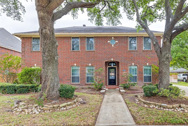 colonial house featuring brick siding