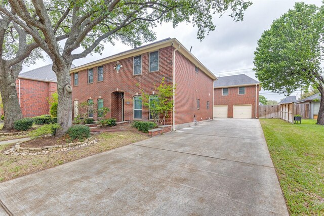colonial home with a garage, a front yard, fence, brick siding, and driveway
