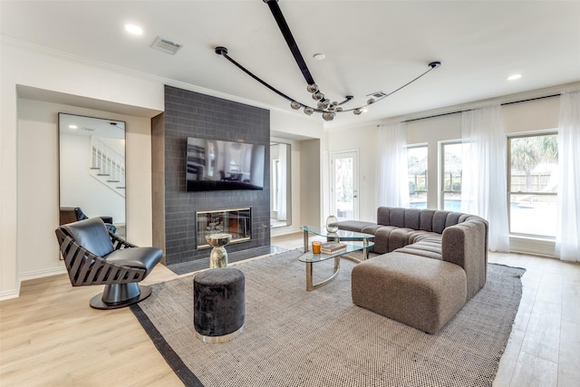 living room with light wood finished floors, a fireplace, visible vents, and recessed lighting