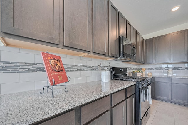25327 Cheshire Knoll St, Katy, TX 77493 - kitchen featuring black appliances, backsplash, light stone countertops, light tile patterned floors, and dark brown cabinetry