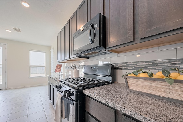 25327 Cheshire Knoll St, Katy, TX 77493 - kitchen with black microwave, gas range oven, backsplash, light tile patterned floors, and dark brown cabinets