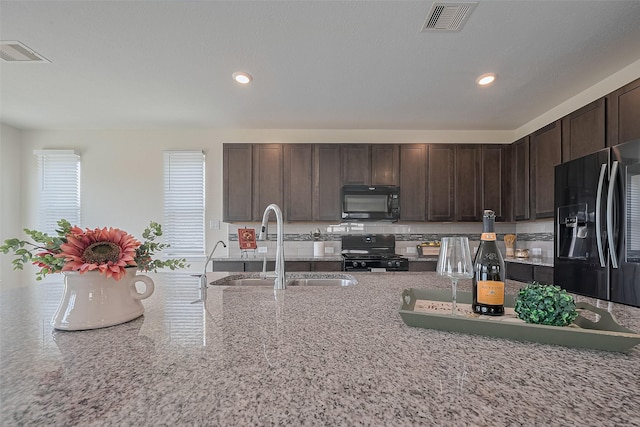 25327 Cheshire Knoll St, Katy, TX 77493 - kitchen featuring black appliances, a sink, dark brown cabinets, recessed lighting, and light stone counters