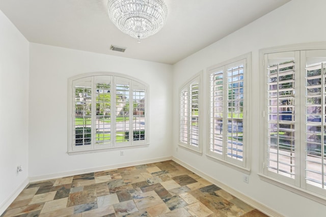 15614 Stone Gables Ln, Houston, TX 77044 - empty room with a chandelier, stone finish floors, and baseboards