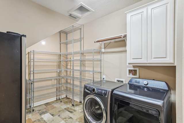 15614 Stone Gables Ln, Houston, TX 77044 - laundry area featuring cabinet space, separate washer and dryer, and light stone finish flooring