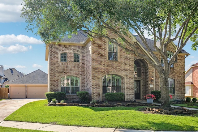 15614 Stone Gables Ln, Houston, TX 77044 - view of front of home with brick siding, driveway, a front yard, a garage, and roof with shingles