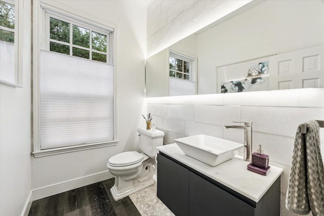 2114 Wroxton Rd, Houston, TX 77005 - half bathroom featuring toilet, baseboards, wood finished floors, and a healthy amount of sunlight