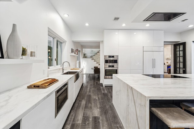 2114 Wroxton Rd, Houston, TX 77005 - kitchen featuring modern cabinets, white cabinetry, visible vents, a sink, and built in appliances