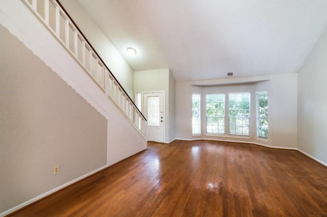 16007 Sierra Vista Dr, Houston, TX 77083 - unfurnished living room featuring visible vents, vaulted ceiling, stairway, wood finished floors, and baseboards