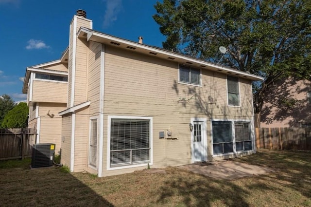 16007 Sierra Vista Dr, Houston, TX 77083 - rear view of house featuring a chimney, a lawn, fence, and central AC