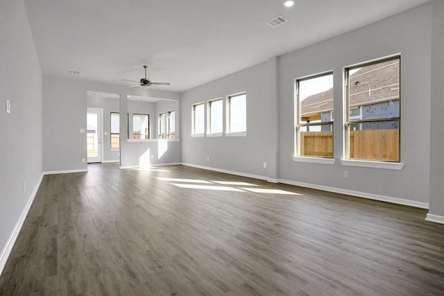 unfurnished living room featuring dark wood finished floors, visible vents, baseboards, and ceiling fan