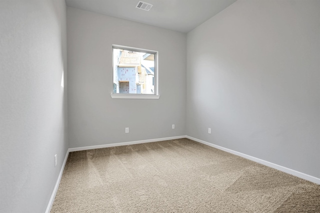 empty room featuring carpet floors, visible vents, and baseboards
