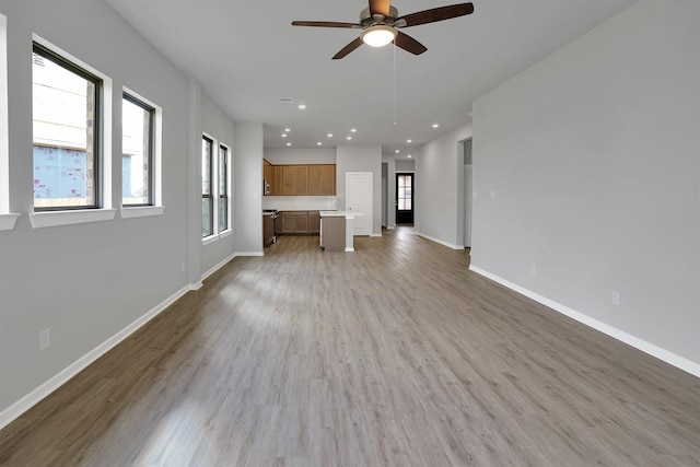 unfurnished living room with recessed lighting, ceiling fan, baseboards, and light wood-type flooring