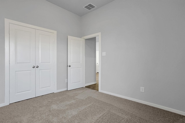 unfurnished bedroom featuring baseboards, visible vents, carpet, and a closet