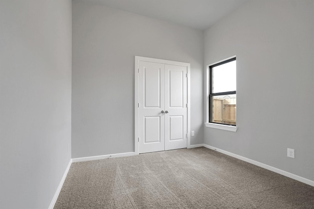 unfurnished bedroom featuring a closet, carpet flooring, and baseboards