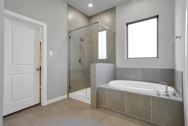 bathroom with a bath, baseboards, tile patterned flooring, and a stall shower