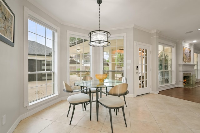 15431 Greens Cove Way, Houston, TX 77059 - dining room with a chandelier, crown molding, baseboards, light tile patterned flooring, and a warm lit fireplace