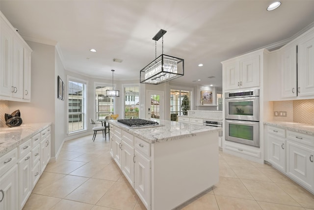 15431 Greens Cove Way, Houston, TX 77059 - kitchen featuring appliances with stainless steel finishes, a kitchen island, light tile patterned floors, tasteful backsplash, and recessed lighting