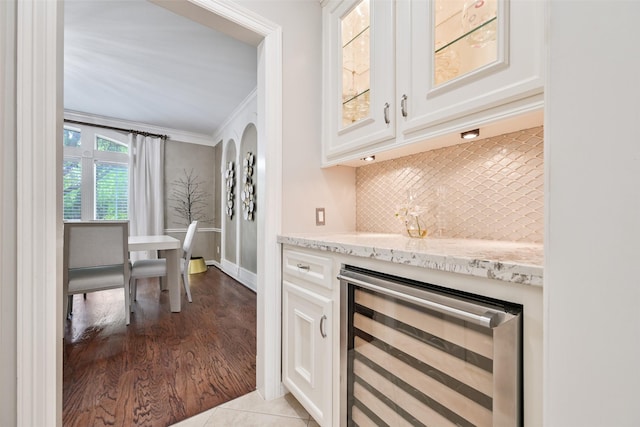 15431 Greens Cove Way, Houston, TX 77059 - indoor dry bar featuring wine cooler, backsplash, crown molding, baseboards, and light wood-type flooring