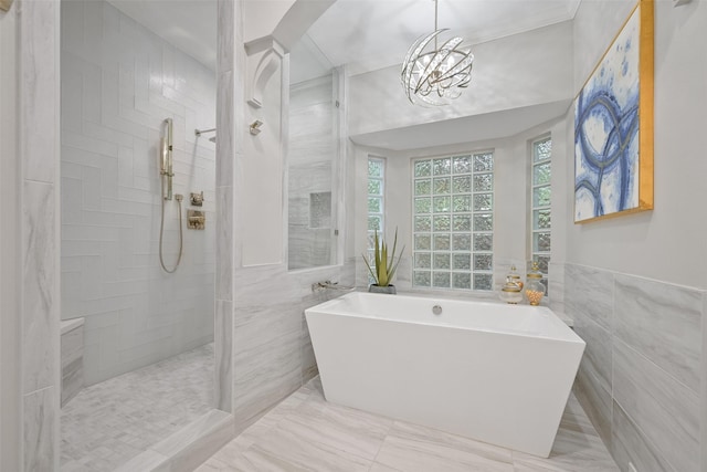 15431 Greens Cove Way, Houston, TX 77059 - full bathroom with tile walls, a freestanding bath, walk in shower, a chandelier, and marble finish flooring