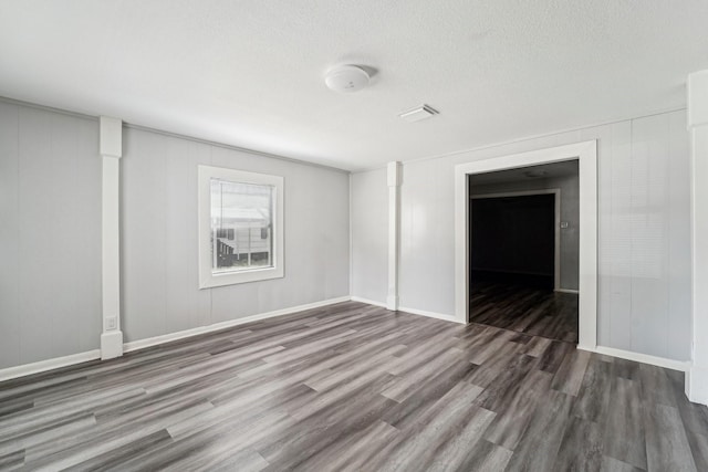 5910 Edward Dr, Houston, TX 77396 - empty room with visible vents, a textured ceiling, baseboards, and wood finished floors
