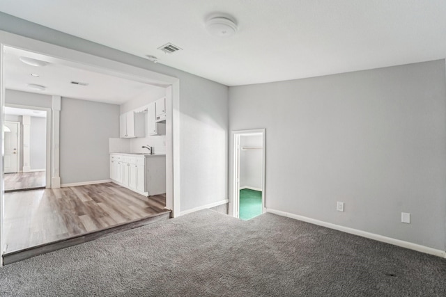 5910 Edward Dr, Houston, TX 77396 - unfurnished living room featuring a sink, visible vents, baseboards, and carpet flooring