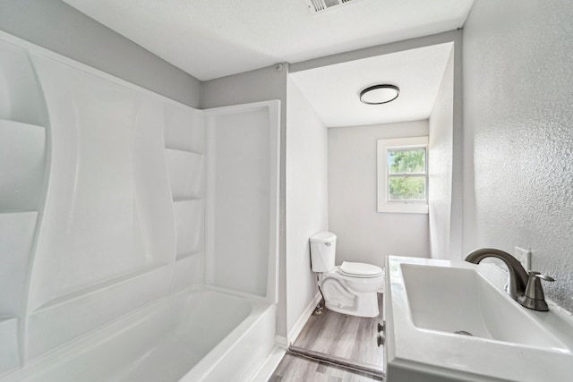 5910 Edward Dr, Houston, TX 77396 - full bathroom with vanity, toilet, wood finished floors, a textured wall, and baseboards