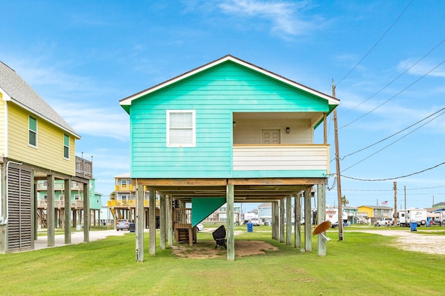 rear view of property featuring a carport, a yard, stairs, and dirt driveway