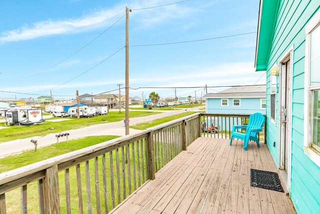 wooden deck with a residential view and a lawn